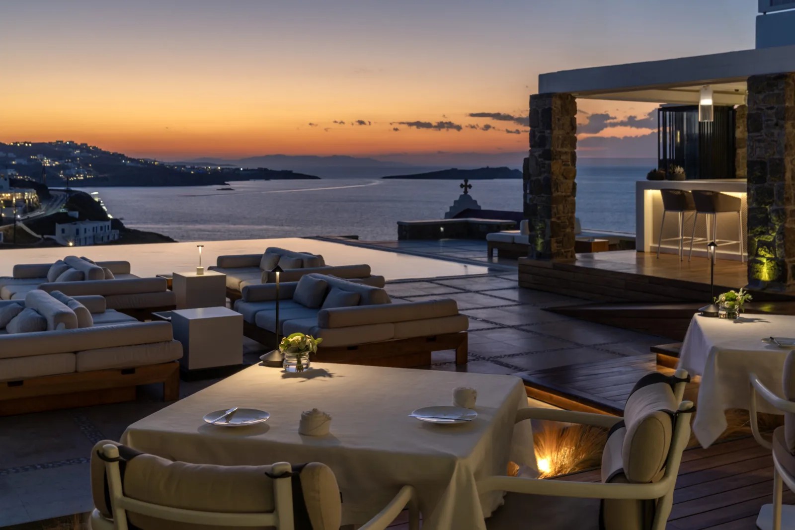 הבריכה האינסופית של מלון Bill & Coo Mykonos עם נוף לים האגאי בשקיעה