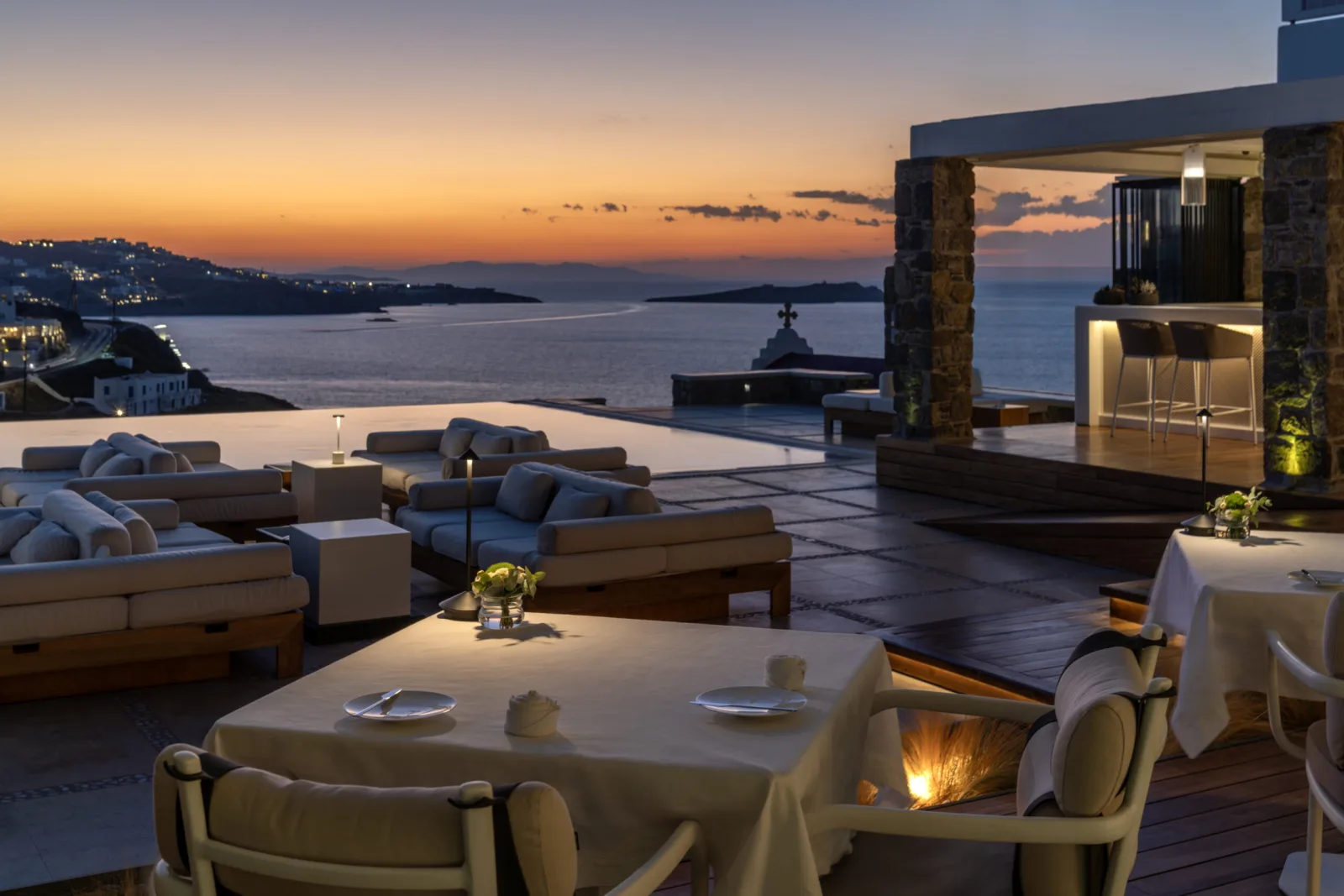 הבריכה האינסופית של מלון Bill & Coo Mykonos עם נוף לים האגאי בשקיעה